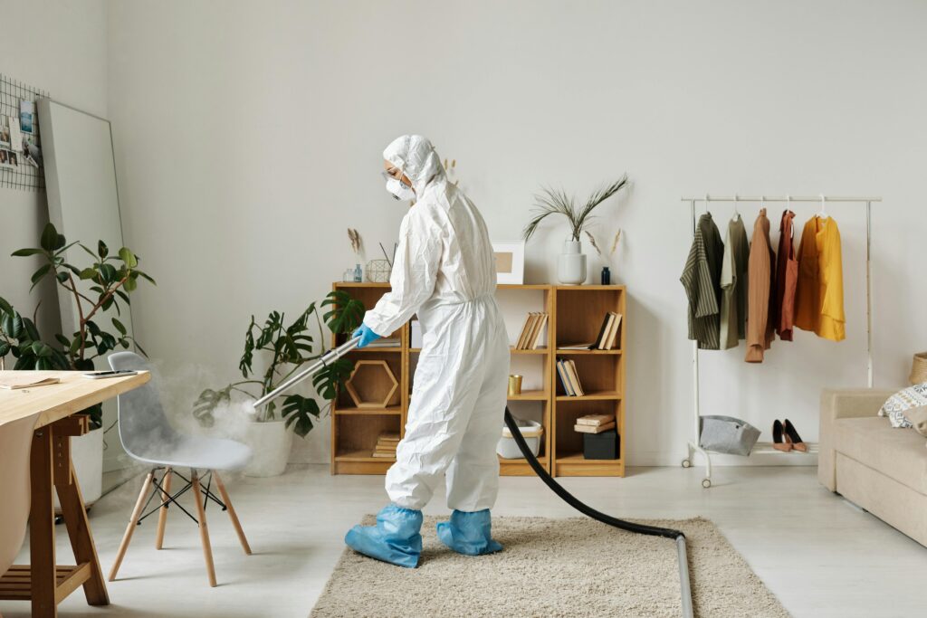 pexels photo 4176036 4176036 A worker in protective gear disinfecting a modern living room with a fogger.