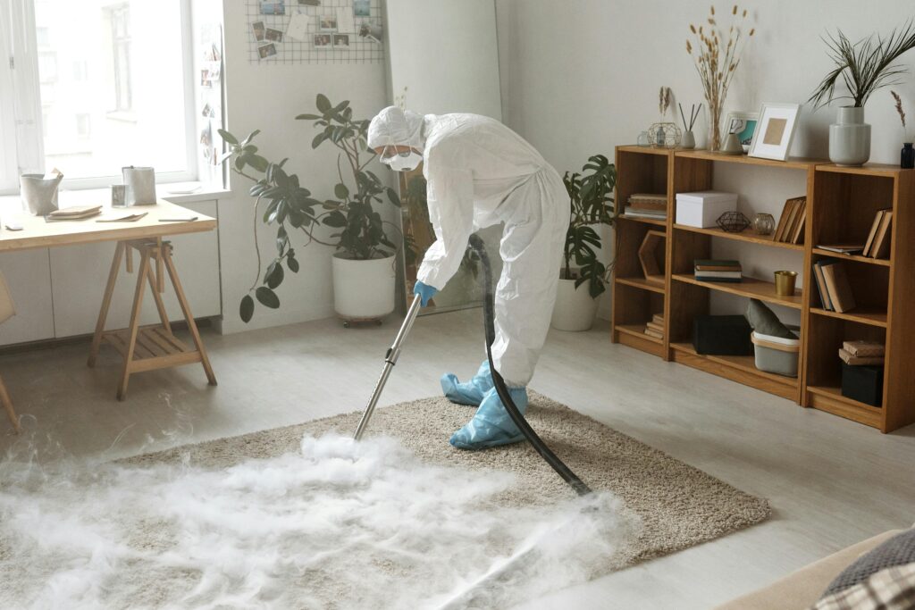 pexels photo 4176302 4176302 A woman in protective gear disinfects a carpet indoors to ensure safety during the COVID-19 pandemic.